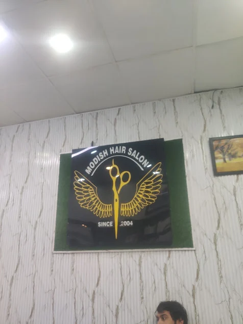 Golden winged shears crest on the Modish salon wall